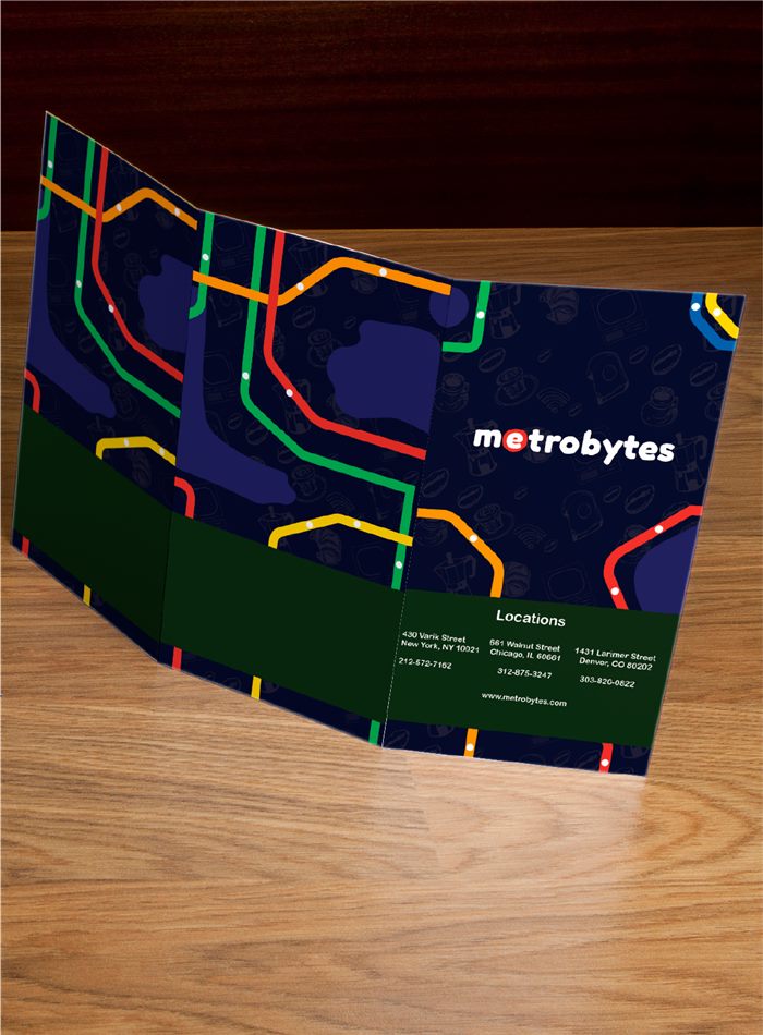 Metrobytes tri-fold brochure on a wooden desk, its cover printed with a colourful subway-map pattern on navy